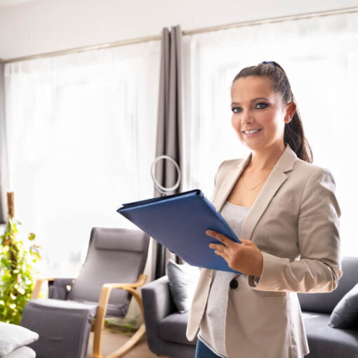 Lady with clipboard in house smiling at camera