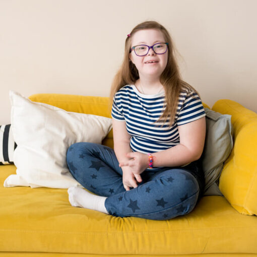 Teenager smiling at camera sitting on couch