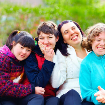 four female friends smiling and hugging